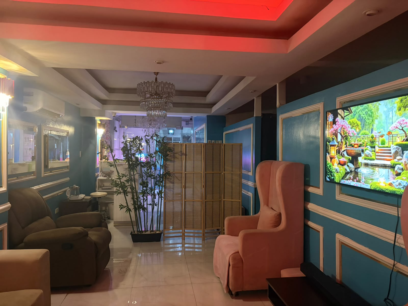 Sue Massage lounge with teal walls and pink armchairs